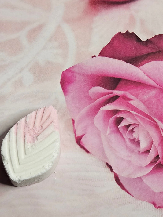 A shower candy designed for relief with a pink and white color scheme, placed next to a rose image, indicating a soothing and relaxing effect.